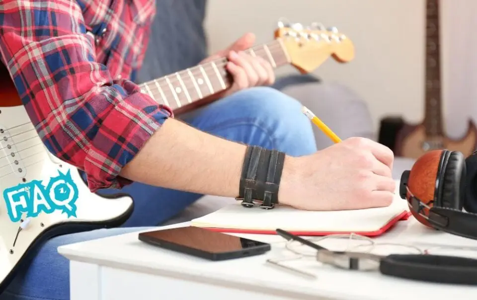 guitar composition FAQ - a person holding a pencil and writing on a notebook